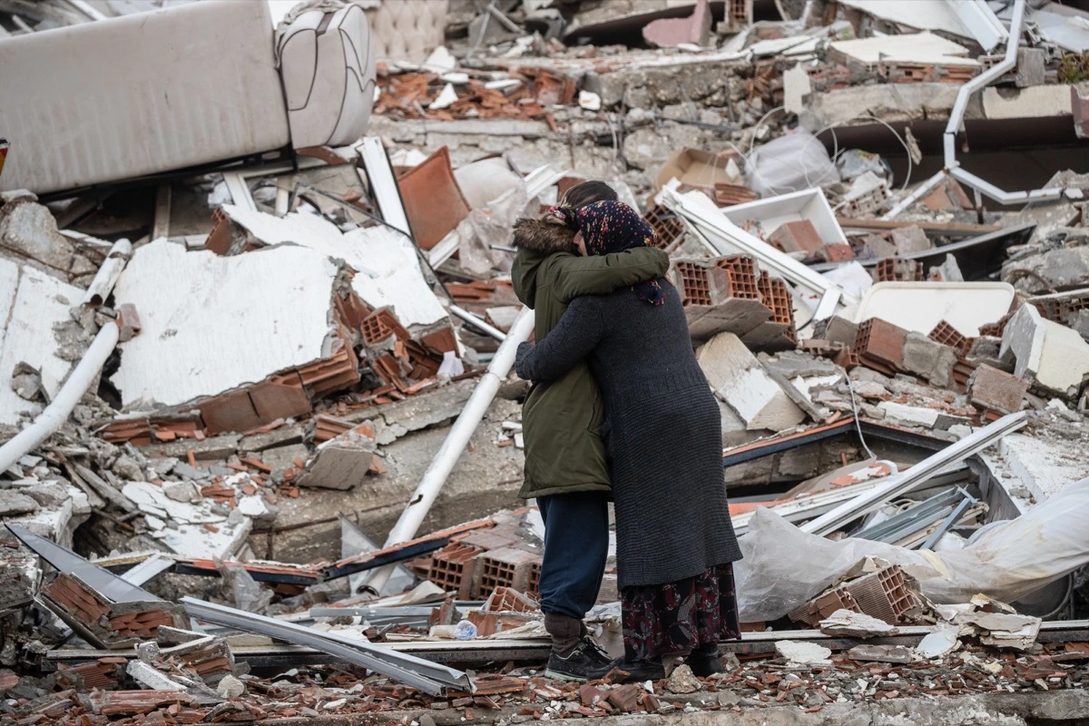 Two women are seen embracing after the Kahramanmaras earthquake concluded. Surrounded by the rubble that took over 19,000 lives of innocent people. Photo credit Burak Kara/Getty Images 